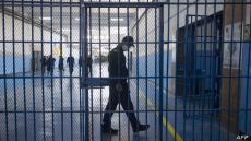 A guard walks behind one of the gates inside the prison of Kenitra, in the coastal city of the same name, near the Moroccan capital Rabat, on August 31, 2021. - After passing through the North African kingdom's Moussalaha ("Reconciliation") programme, some prisoners are hoping for a reprieve. The programme, launched in 2015 and led by Morocco's DGAPR prison service with several partner organisations, aims to help terror detainees who are willing to question their beliefs. (Photo by FADEL SENNA / AFP)